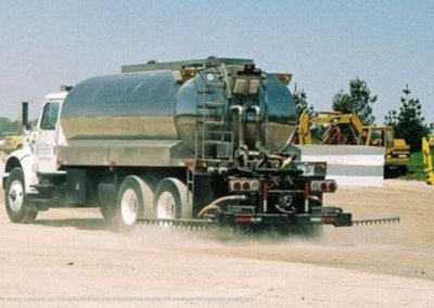 An image of the rear side of a Gasaway Maintenance Company truck applying dust control formula in Naperville, IL.