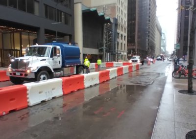 Water tank truck delivers water to fill barricades at job site in Chicago, IL