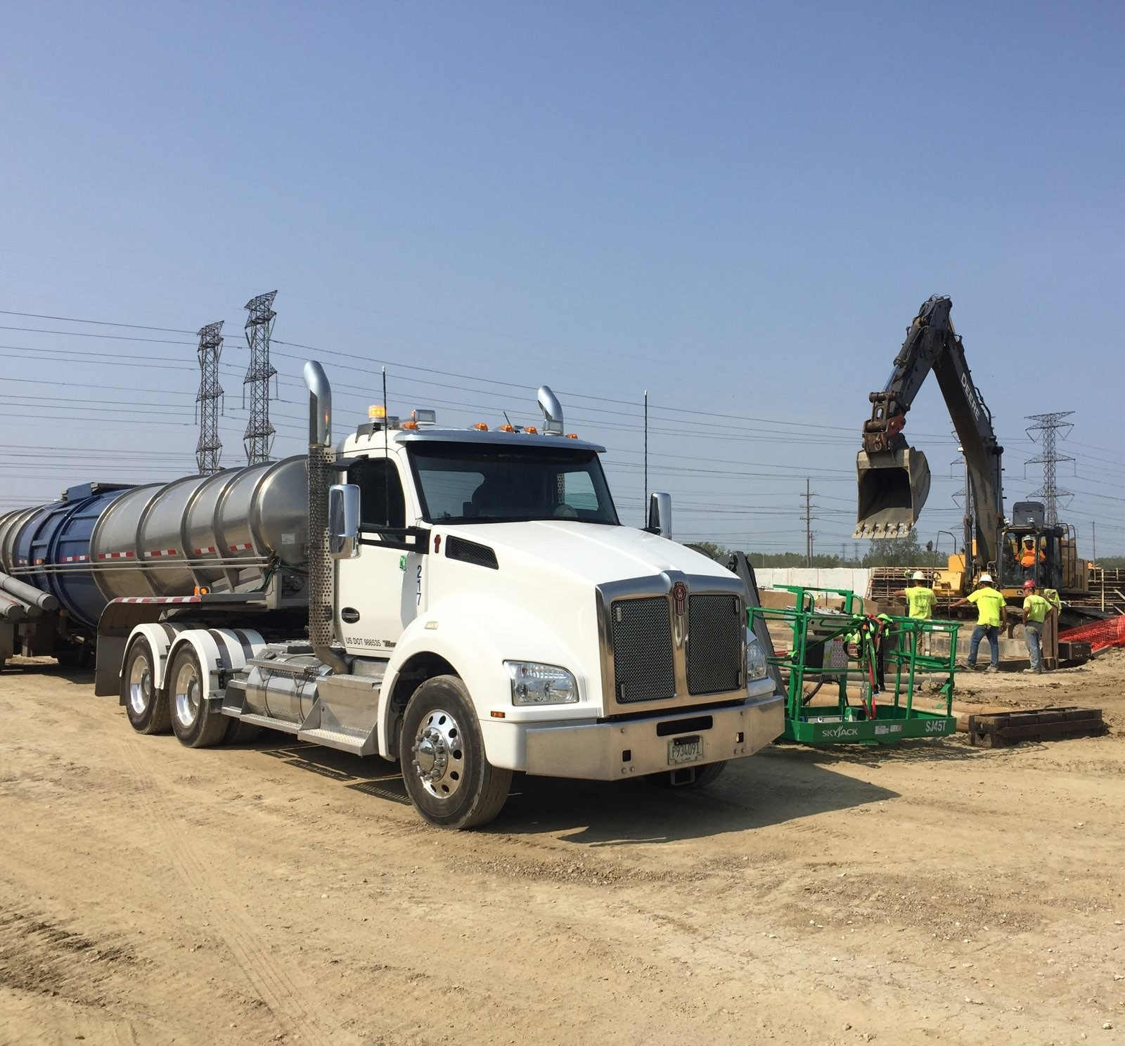 A Gasaway Maintenance Company truck parked at a dusty construction site in Dundee, IL, with an excavator nearby.